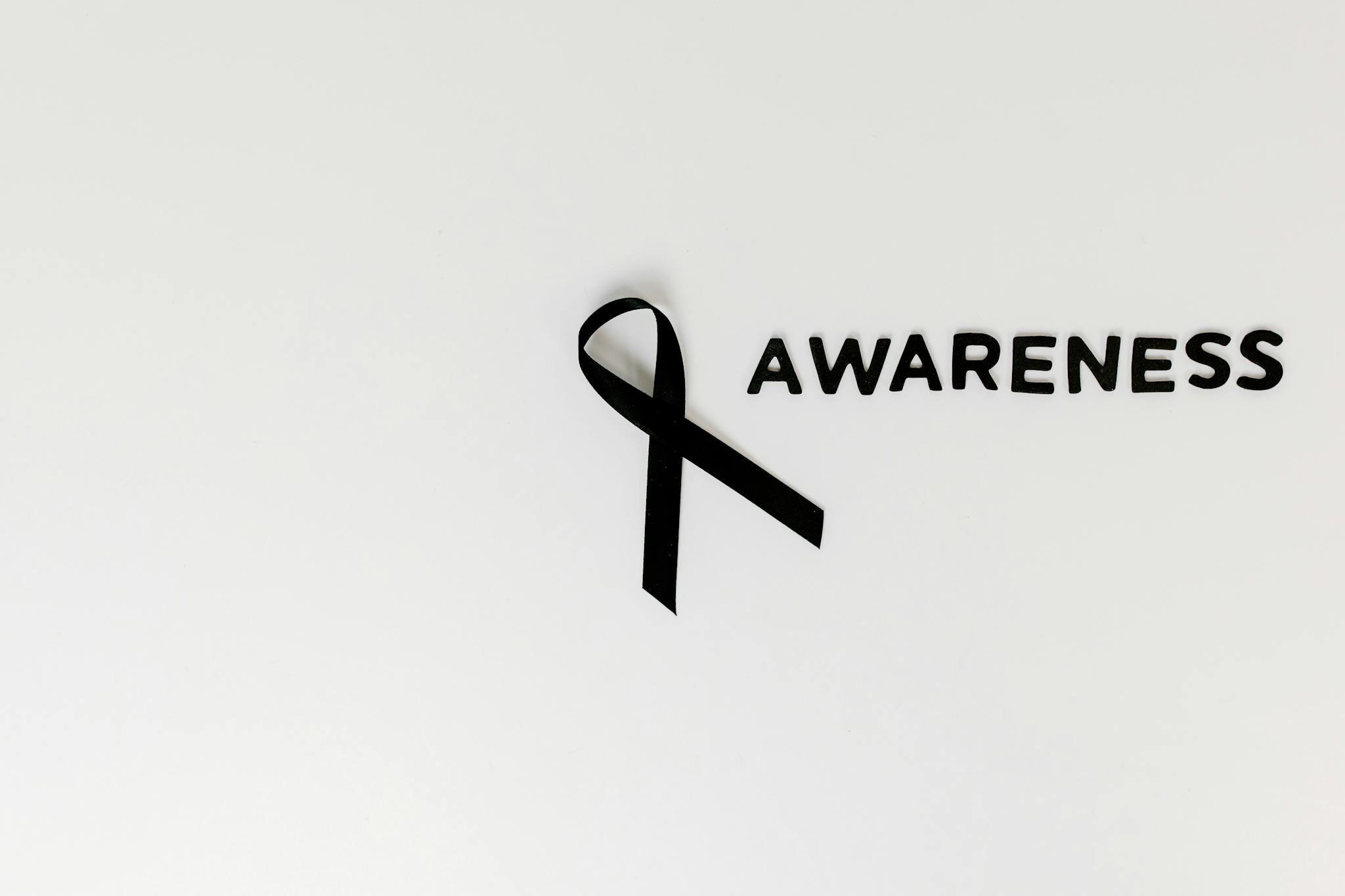 Conceptual image of a black ribbon with 'awareness' text on white background.