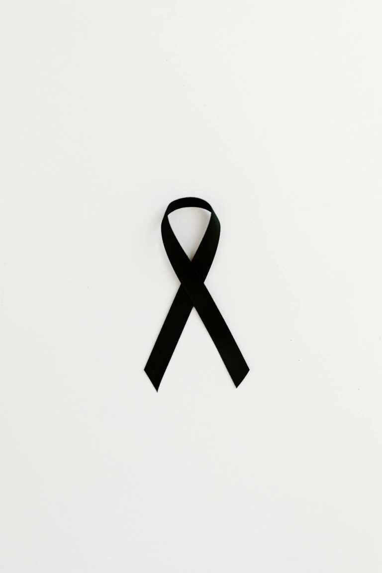 Minimalist black ribbon symbolizing cancer awareness on white background.